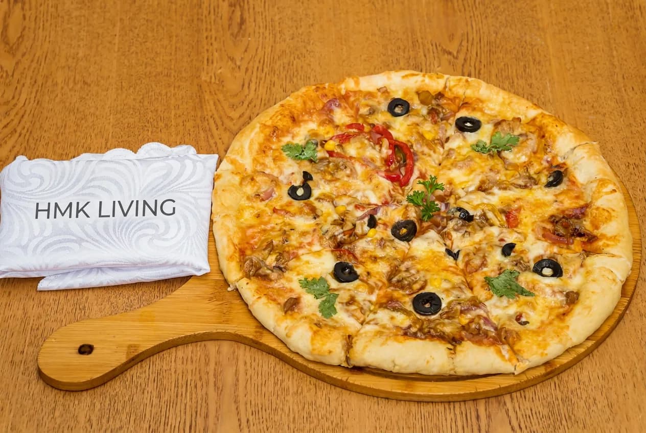 Freshly made pizza served from the ground-floor restaurant kitchen at HMK Living, Kigo Kampala