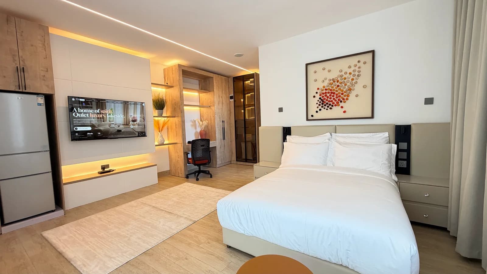 Studio with media wall, desk and king bed at HMK Living, Kigo Kampala